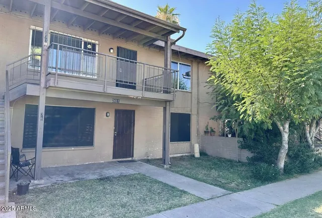 a view of a house with a yard and large tree