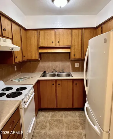 a kitchen with a refrigerator a stove and wooden cabinets