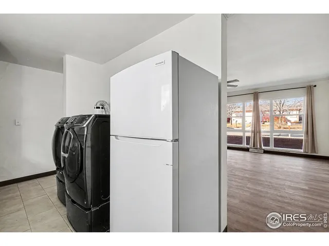 a view of kitchen with refrigerator and wooden floor