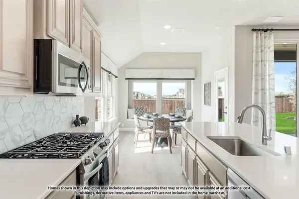 a kitchen with stainless steel appliances granite countertop a stove a sink dishwasher and white cabinets with wooden floor