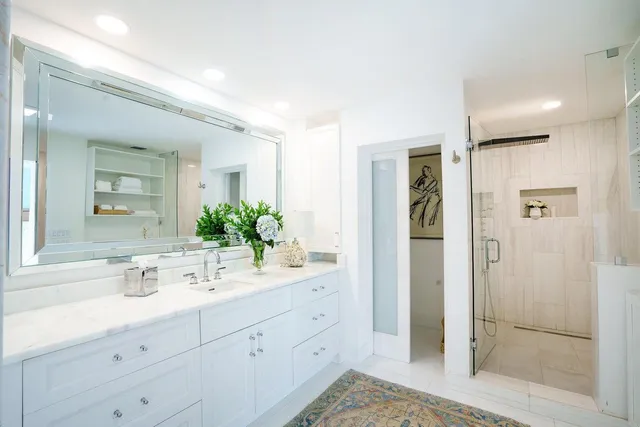 a bathroom with a double vanity sink mirror and shower