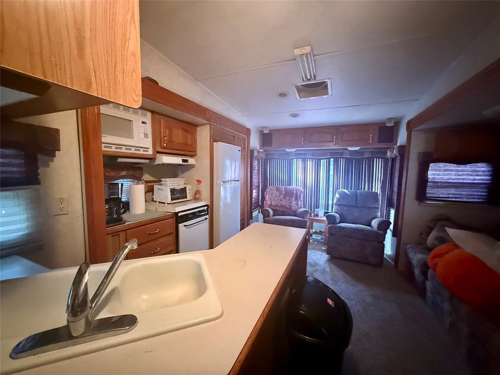 314 Blackjack Street Yantis, TX 75497 - Photo 26 of 26 a living room with stainless steel appliances kitchen island granite countertop furniture a rug and a window