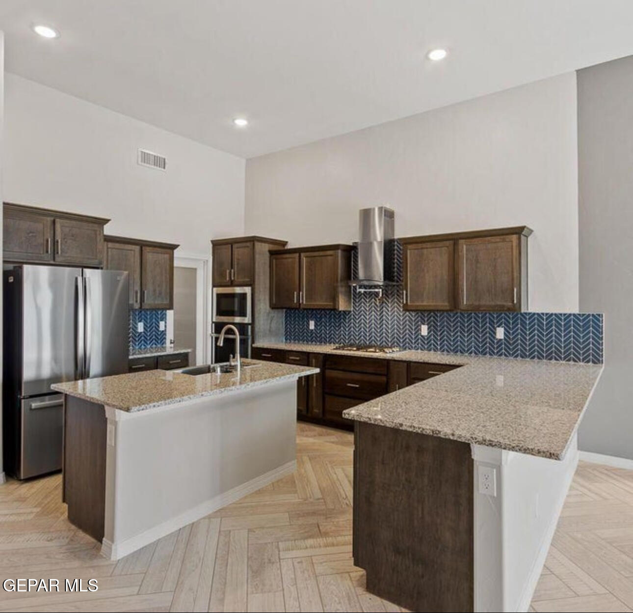 6056 Summer Ridge Street Sunland Park, NM 88008 - Photo 3 of 12 a kitchen with stainless steel appliances granite countertop a sink a stove a refrigerator a microwave oven with white cabinets