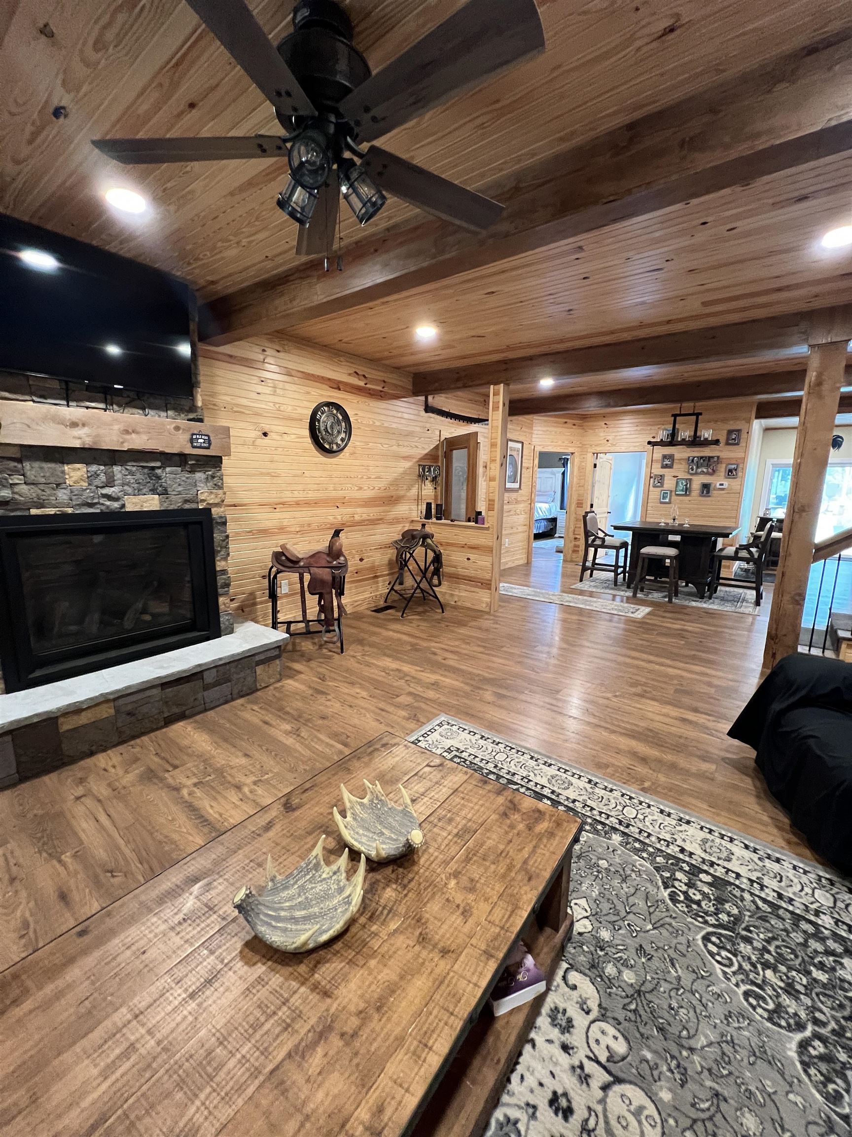5205 Hamburg Road Michie, TN 38357 - Photo 7 of 40 Living area featuring a stone fireplace, wood finished floors, a wooden ceiling with exposed beams, recessed lighting, and a ceiling fan