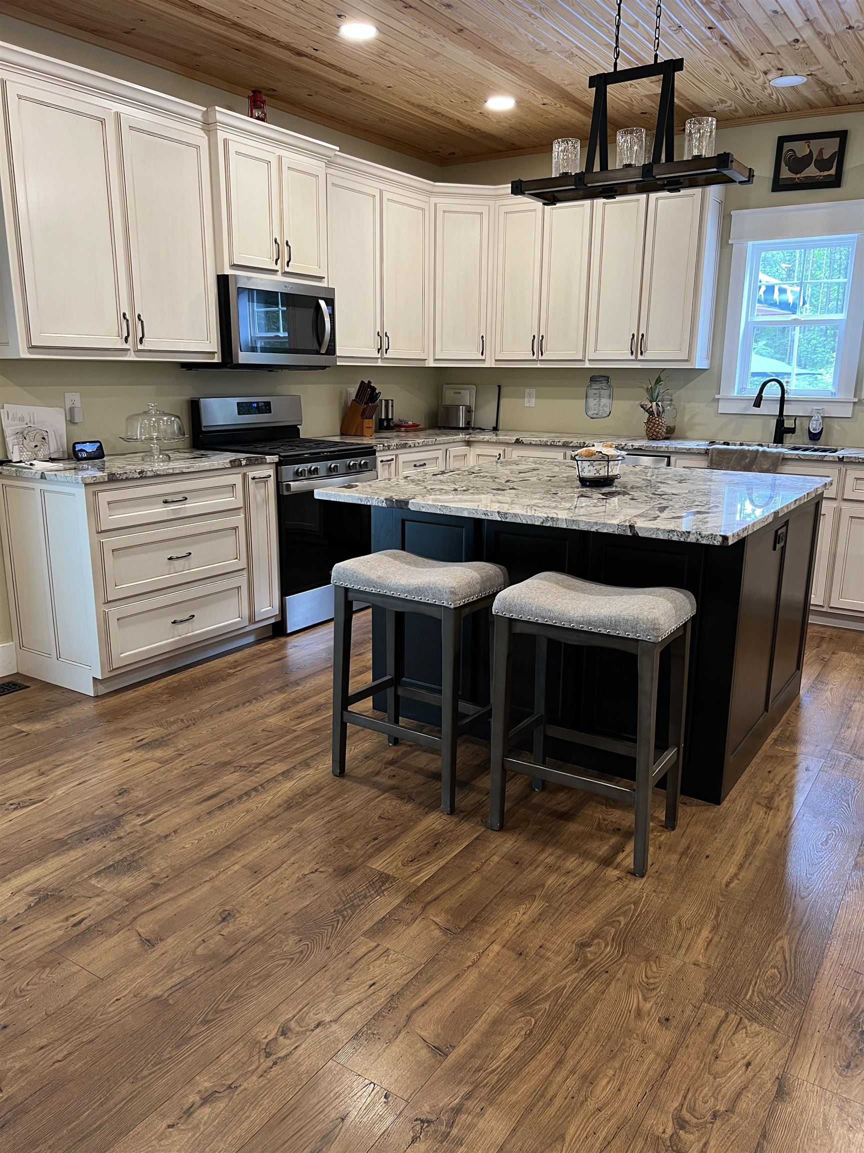5205 Hamburg Road Michie, TN 38357 - Photo 9 of 40 Kitchen featuring wooden ceiling, stainless steel appliances, white cabinetry, a center island, and dark wood-type flooring