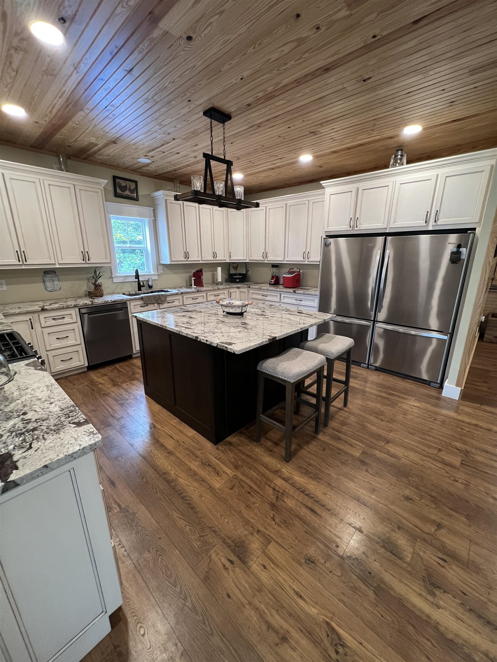 5205 Hamburg Road Michie, TN 38357 - Photo 10 of 40 Kitchen featuring wooden ceiling, freestanding refrigerator, a kitchen island, and white cabinetry