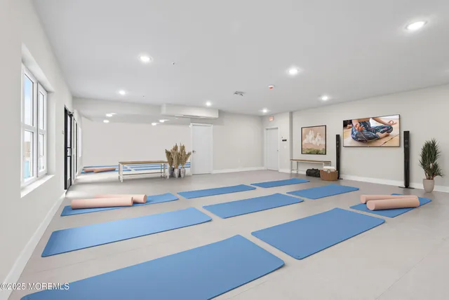 a living room with kitchen island stainless steel appliances furniture and a wooden floor