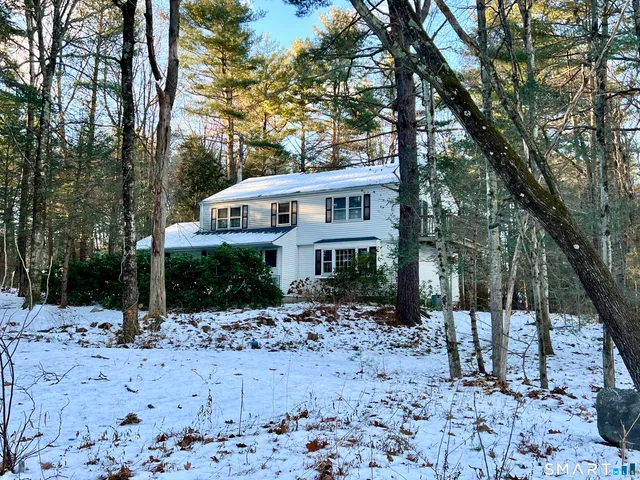 a front view of a house with a yard covered in snow