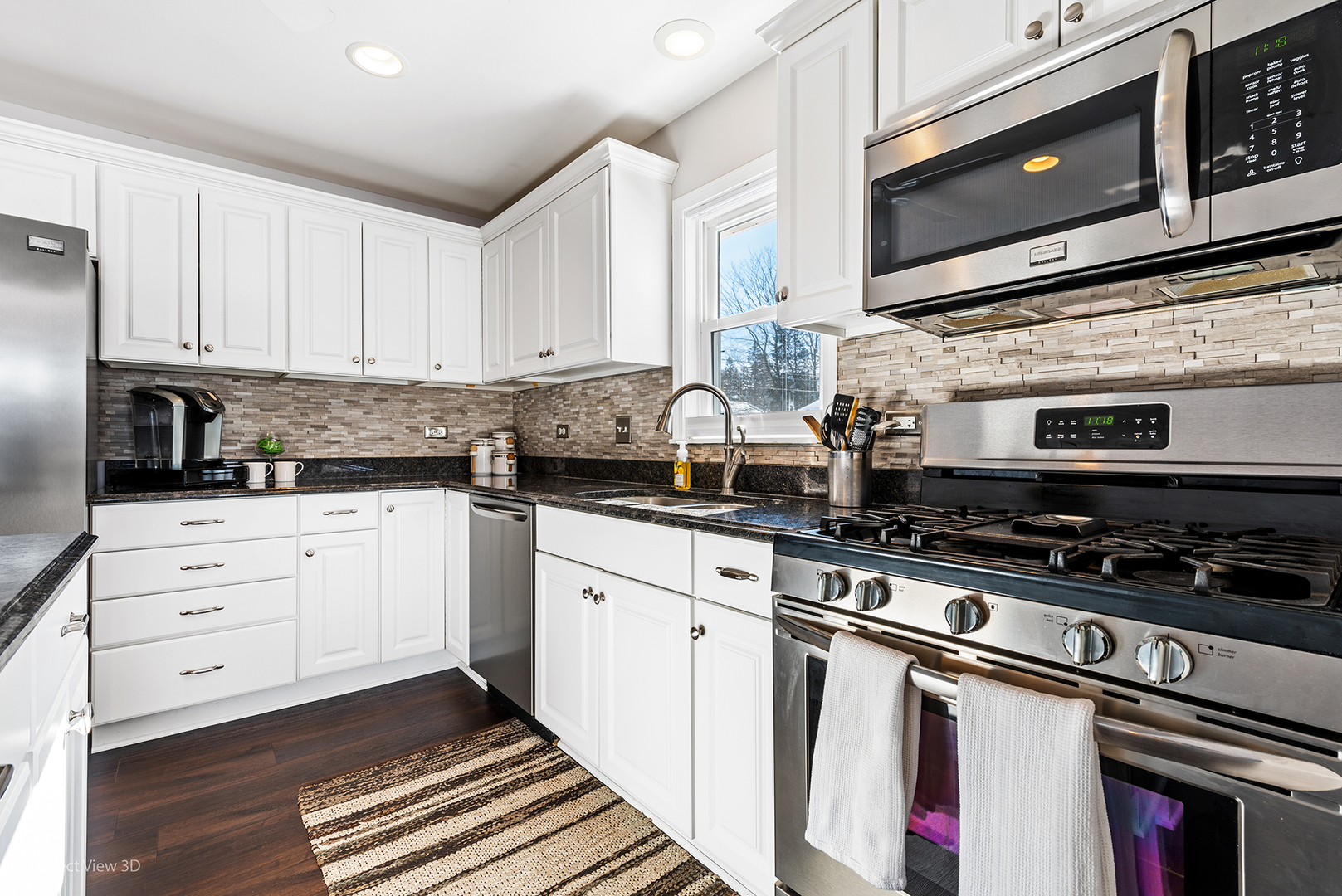 21 Crescent Road Lake Zurich, IL 60047 - Photo 8 of 24 a kitchen with stainless steel appliances granite countertop a stove a sink and a microwave