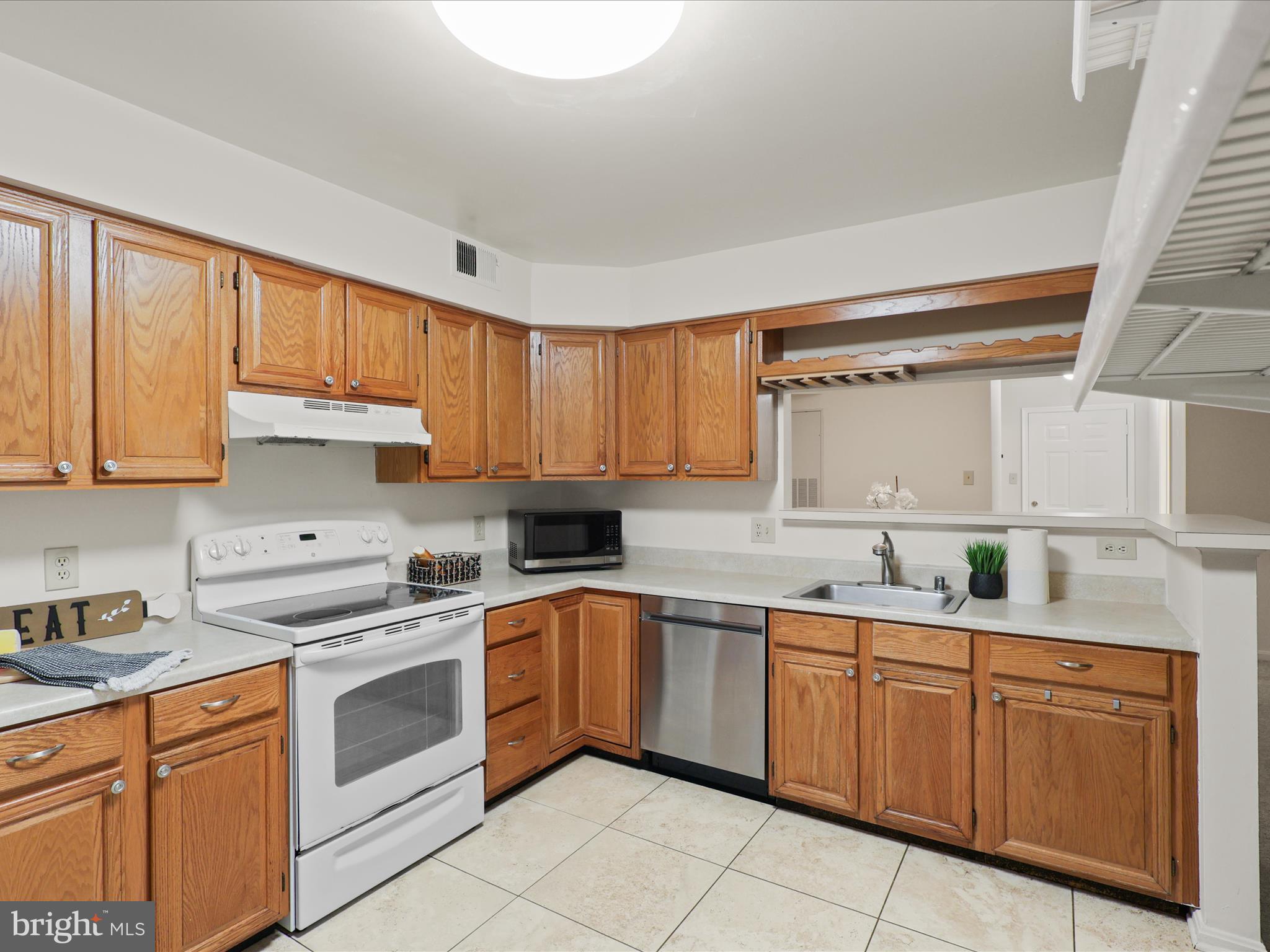11713 Karbon Hill Court, Unit 710A Reston, VA 20191 - Photo 13 of 19 a kitchen with a sink stove and cabinets