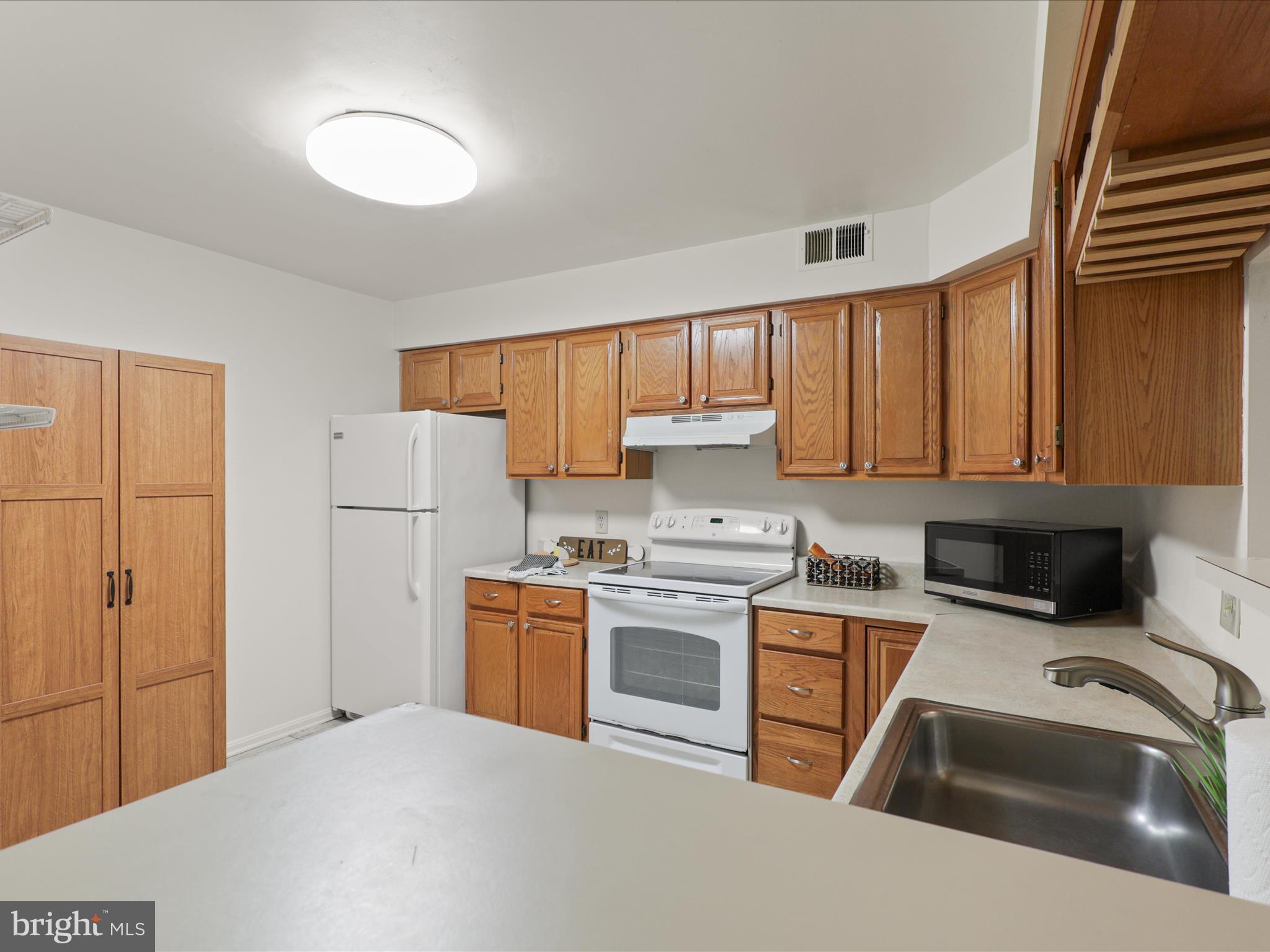 11713 Karbon Hill Court, Unit 710A Reston, VA 20191 - Photo 14 of 19 a kitchen with a sink a stove and cabinets