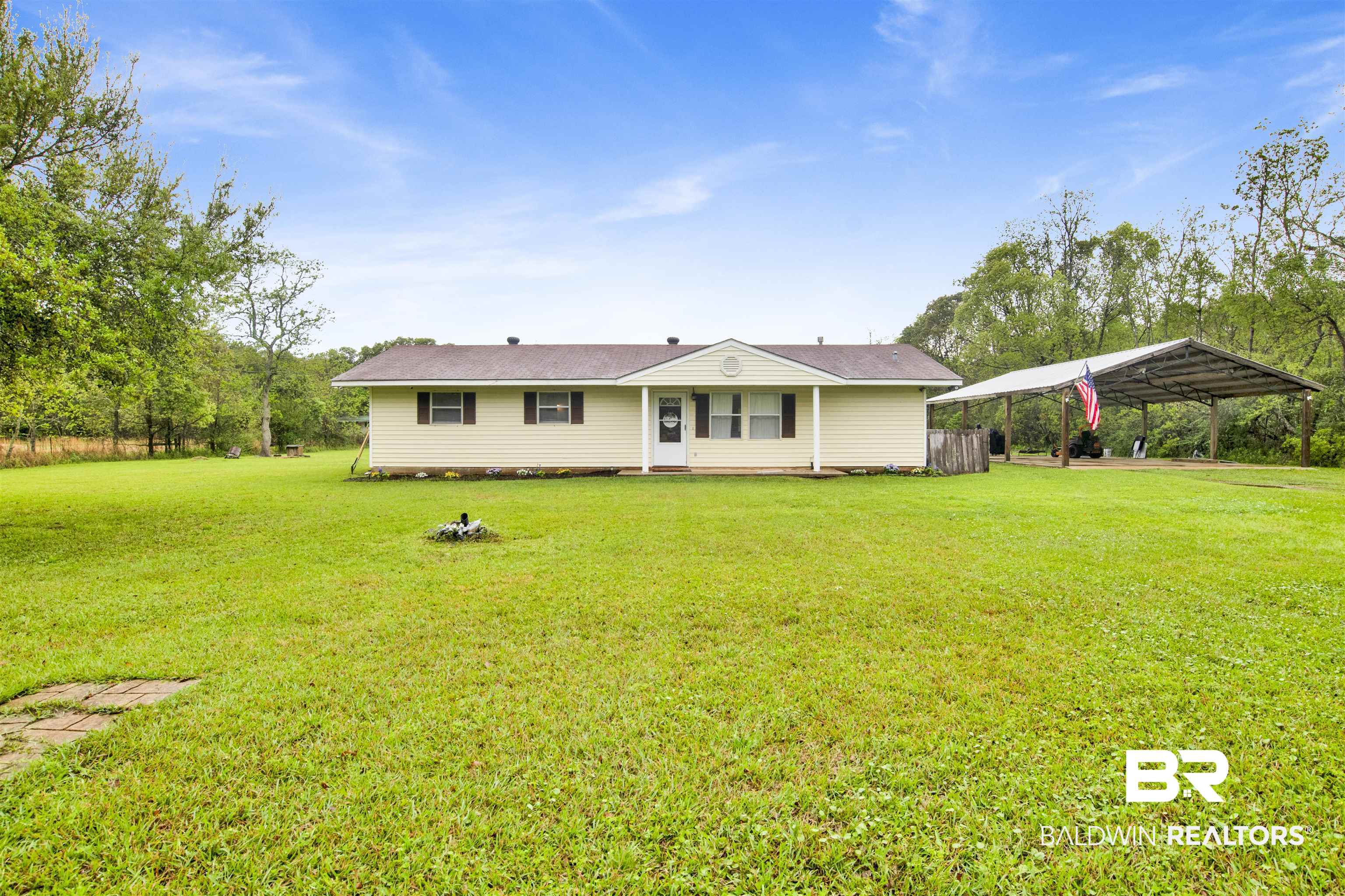 10244 Magnolia Road Irvington, AL 36544 - Photo 1 of 37 View of front facade with a front lawn and a carport