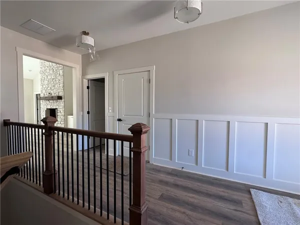 a view of a hallway with wooden floor and staircase