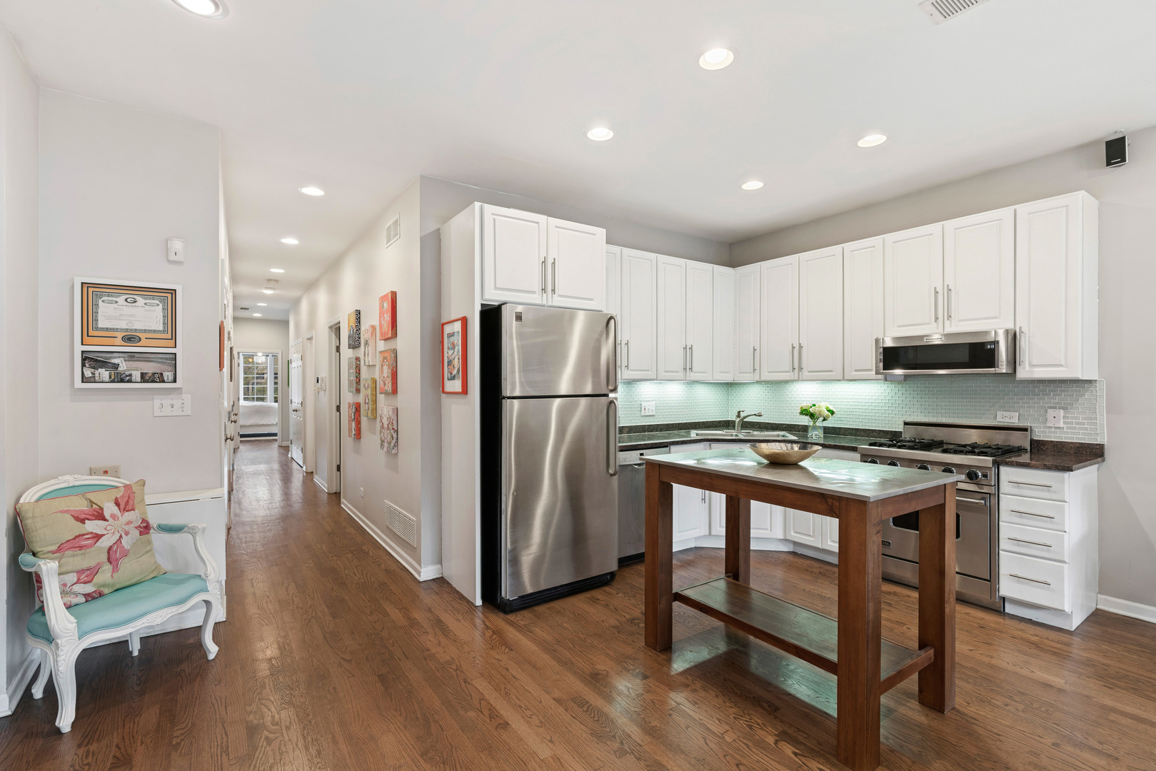 931 West Wolfram Street, Unit 2 Chicago, IL 60657 - Photo 6 of 13 a kitchen with stainless steel appliances granite countertop a refrigerator stove microwave and sink