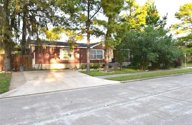a view of a house with a big yard and large trees