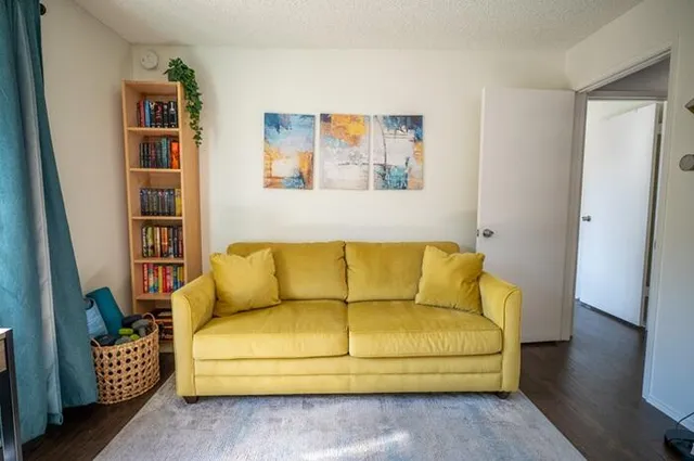 a couch sitting in a living room with a book shelf