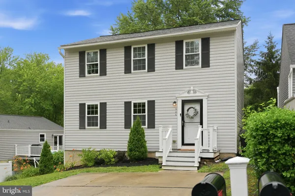 a front view of a house with a tree