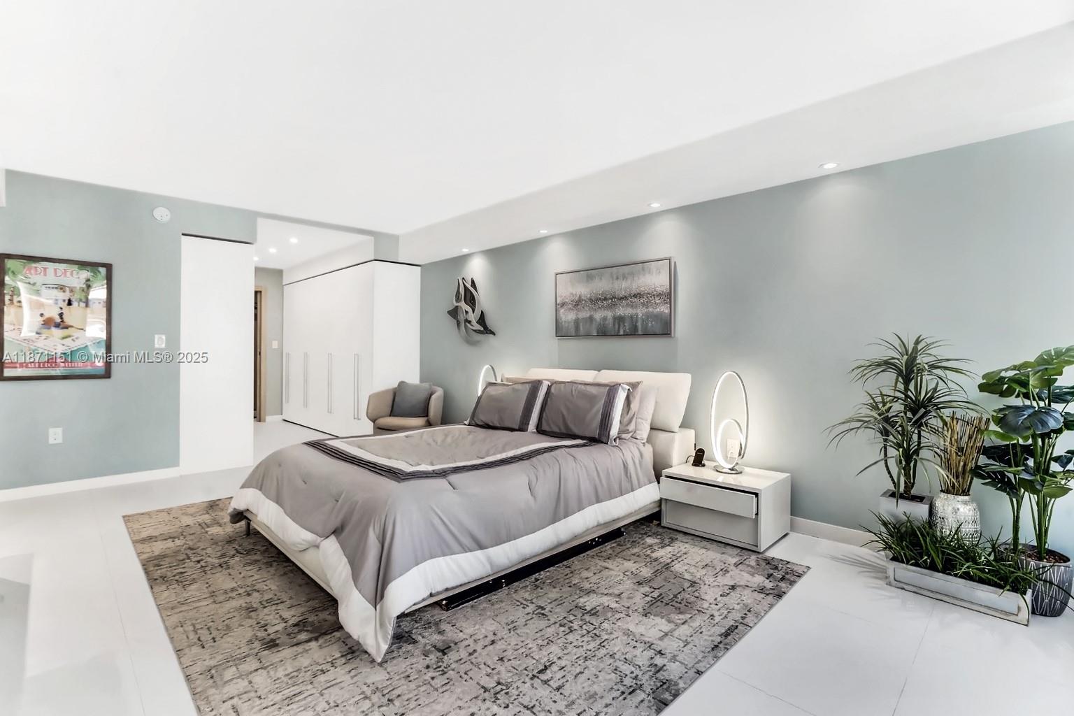 10155 Collins Avenue, Unit 606 Bal Harbour, FL 33154 - Photo 16 of 48 a bedroom with a bed and a potted plant