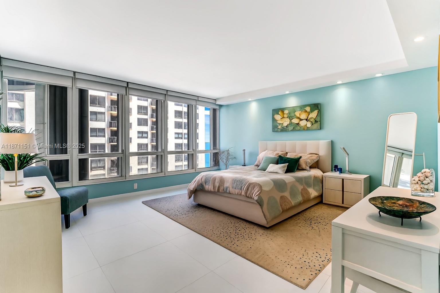 10155 Collins Avenue, Unit 606 Bal Harbour, FL 33154 - Photo 23 of 48 a spacious bedroom with a bed and a large window