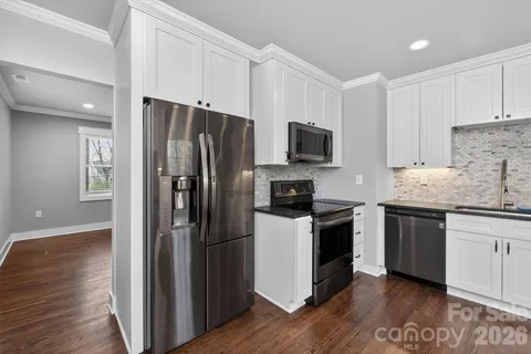 a kitchen with a refrigerator stove and wooden cabinets