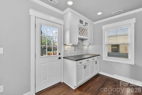 a kitchen with granite countertop white cabinets and a wooden floor