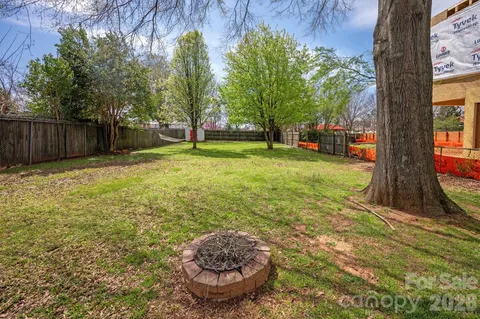 a view of a backyard with large trees and plants