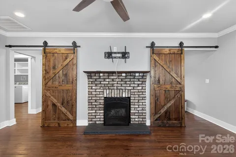 a living room with wooden floors and a fireplace