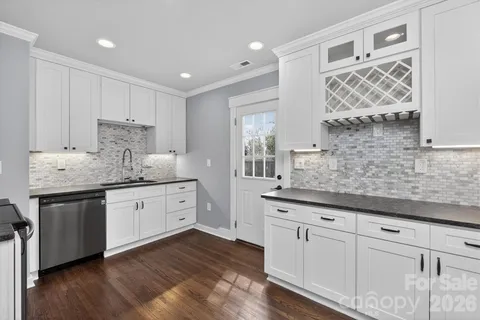 a kitchen with granite countertop white cabinets and white stainless steel appliances