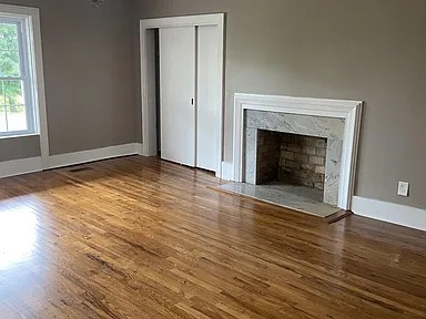 11495 Guthrie Road Guthrie, KY 42234 - Photo 7 of 7 an empty room with wooden floor fireplace and windows