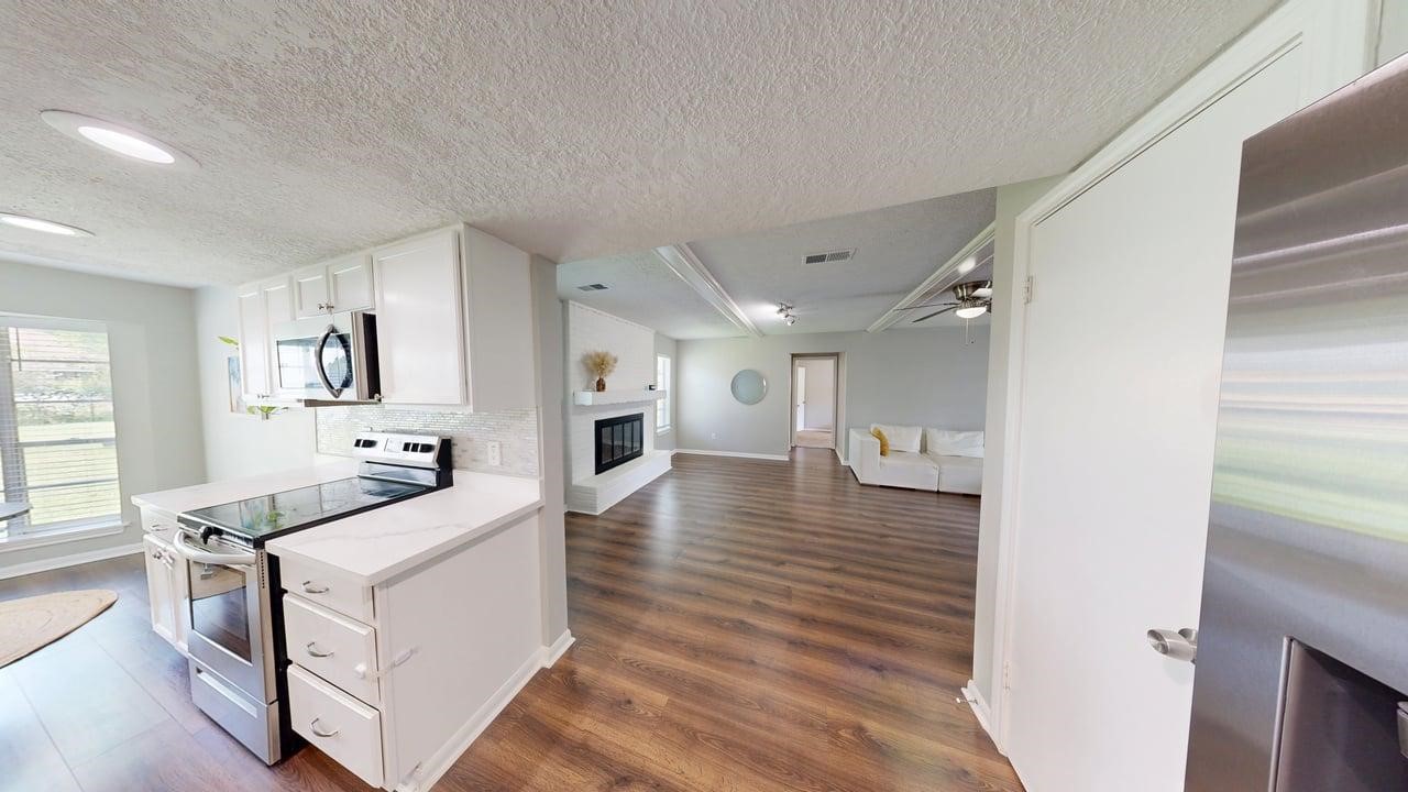 619 Cotter Drive Spring, TX 77373 - Photo 19 of 50 a kitchen with a sink and white cabinets with wooden floor