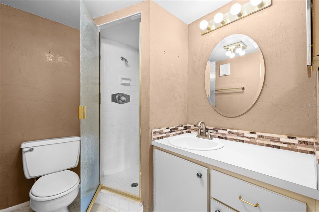 12300 Vonn Road, Unit 1205 Largo, FL 33774 - Photo 26 of 32 a bathroom with a toilet a sink and a mirror