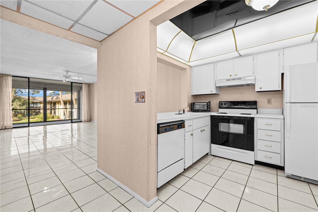 12300 Vonn Road, Unit 1205 Largo, FL 33774 - Photo 4 of 32 a kitchen with stainless steel appliances granite countertop a stove a sink and a refrigerator