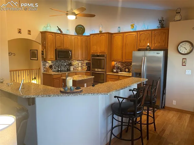 a kitchen with stainless steel appliances kitchen island granite countertop a refrigerator and a stove