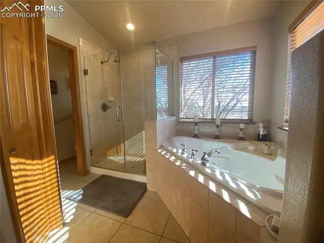 a spacious bathroom with a tub shower and windows