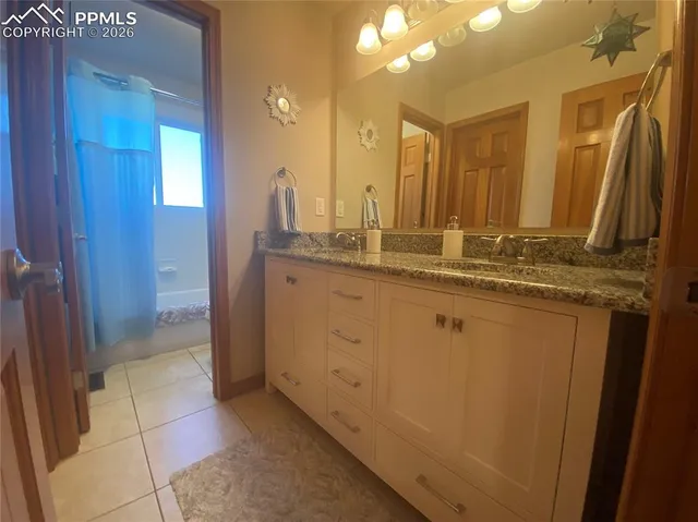 a bathroom with a granite countertop sink a mirror and a shower