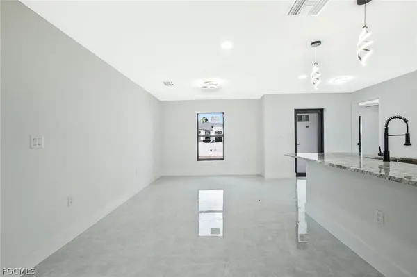 a kitchen with stainless steel appliances granite countertop a refrigerator a sink dishwasher a stove and white cabinets