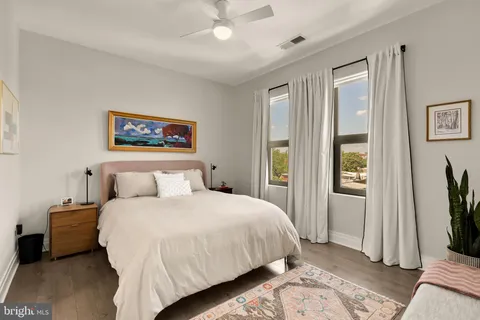 a bedroom with a bed a mirror and a window
