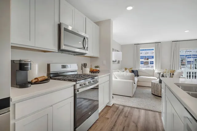 a kitchen with cabinets wooden floor and stainless steel appliances