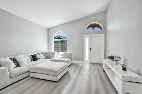 a kitchen with a sink appliances cabinets and a window