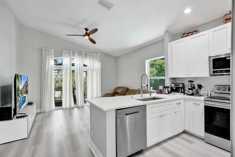 a kitchen with stainless steel appliances a refrigerator sink and microwave