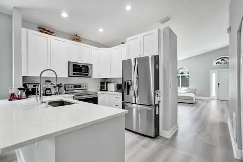 a kitchen with stainless steel appliances kitchen island sink refrigerator and microwave
