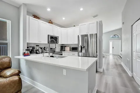 a kitchen with white cabinets and stainless steel appliances