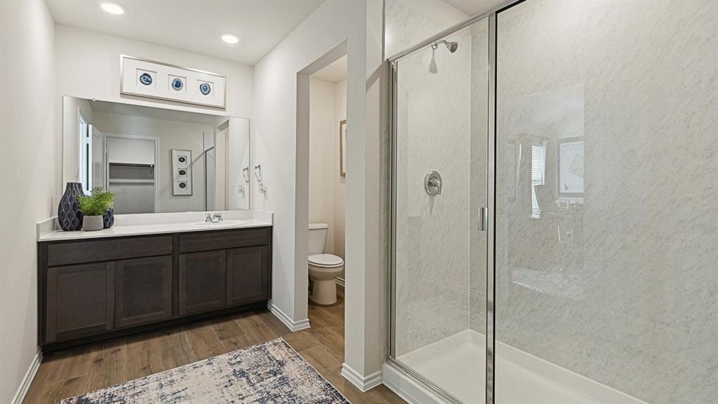 120 Pheasant Run Road Lavon, TX 75166 - Photo 9 of 17 Bathroom featuring a marble finish shower, vanity, and light wood-style floors