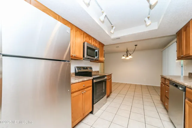 a kitchen with stainless steel appliances a refrigerator sink and microwave