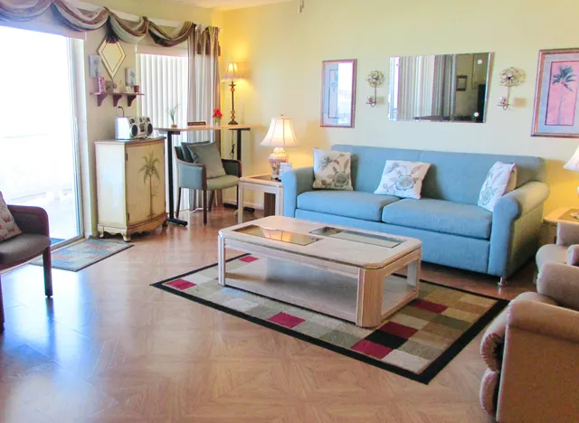 a living room with furniture a large window and a table