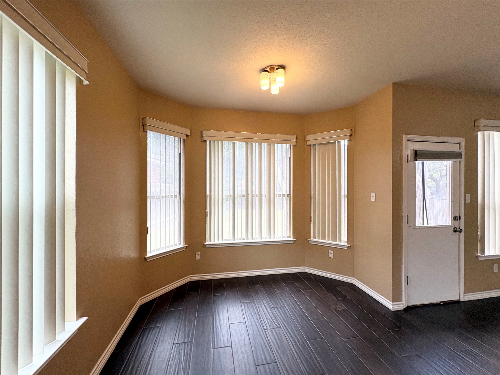 8103 Ephraim Road Austin, TX 78717 - Photo 14 of 35 Rich hardwood floors complement the natural light streaming through a series of windows in this inviting dining area.