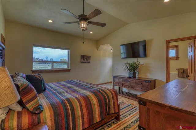 a bedroom with a bed and a flat screen tv