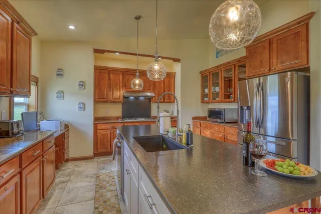 a kitchen with stainless steel appliances granite countertop a sink refrigerator and cabinets