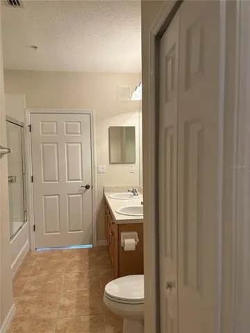 a bathroom with a granite countertop sink a toilet and a shower