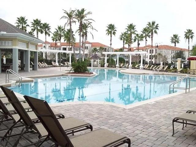 8168 Boat Hook Loop, Unit 707 Windermere, FL 34786 - Photo 2 of 17 a view of a swimming pool with a patio and a lake view